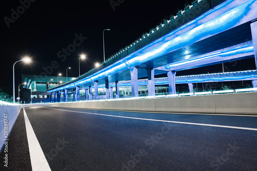Empty road floor with city viaduct bridge of neon lights night