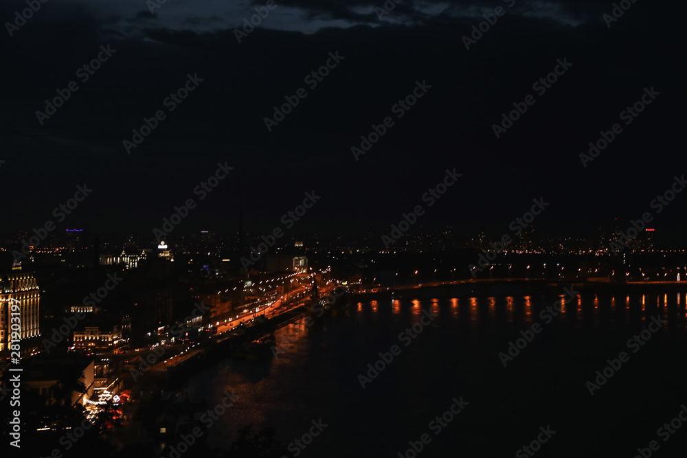 KYIV, UKRAINE - MAY 21, 2019: Beautiful view of night cityscape with illuminated buildings near river