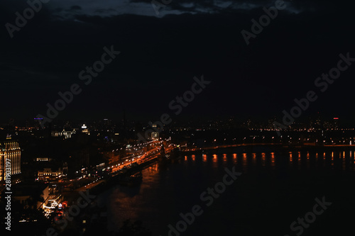 KYIV, UKRAINE - MAY 21, 2019: Beautiful view of night cityscape with illuminated buildings near river