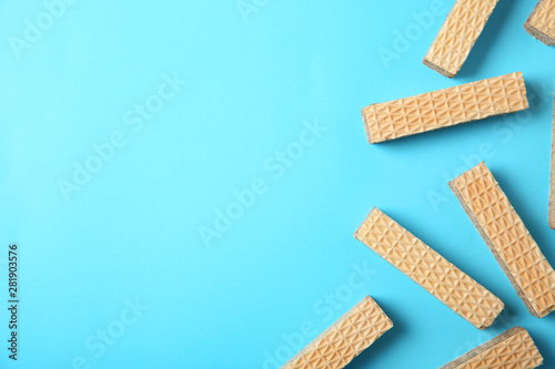 Flat lay composition with delicious crispy wafers on blue background. Space for text