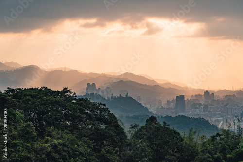 Layers of Taipei cityscape and mountains with sunlight when the sun going down that view from Xiangshan Elephant Mountain in the evening in Taipei, Taiwan.
