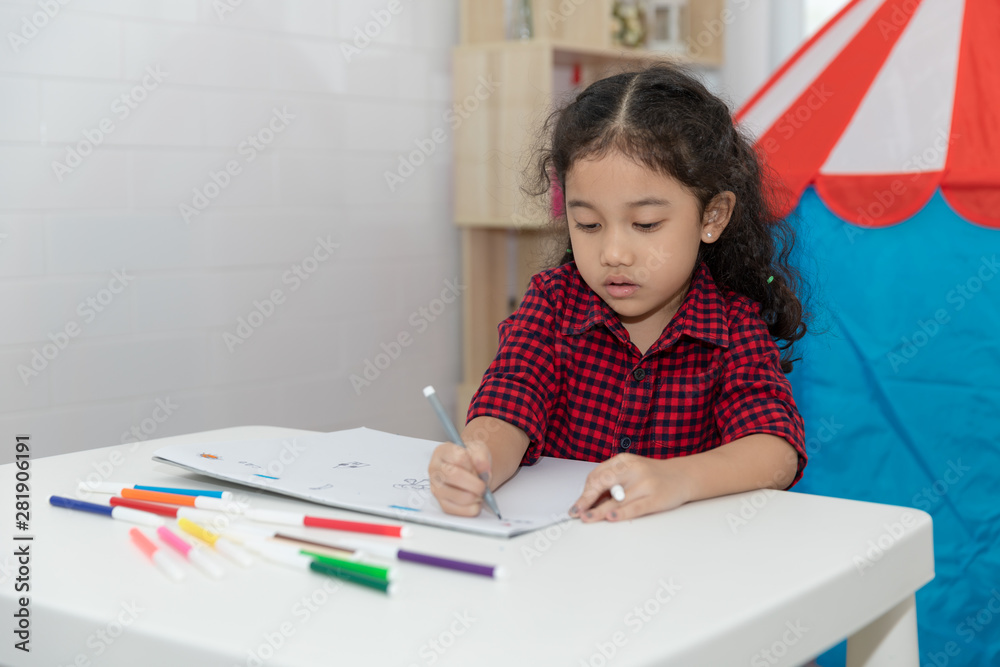 baby asian girl sitting drawing on paper book on the white table in the room baby asian girl sitting drawing on paper book on the white table in the room