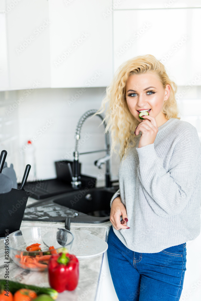 Healthy food at home. Happy woman is preparing the vegetables in the kitchen.
