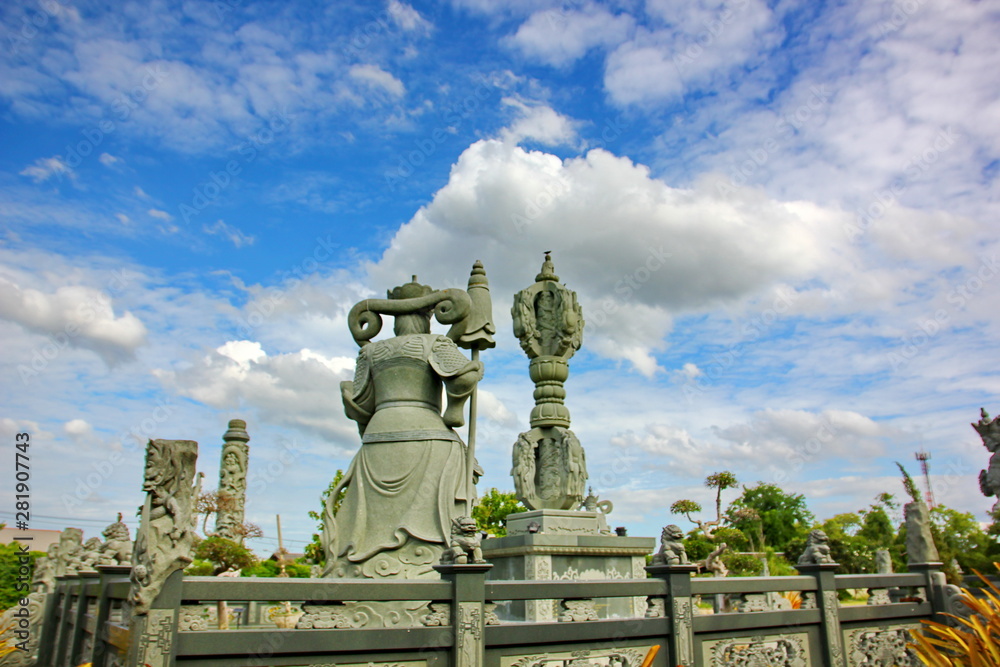 Chinese god stone carving with blue sky white cloud in Thai land.