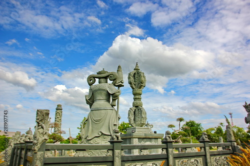 Chinese god stone carving with blue sky white cloud in Thai land.