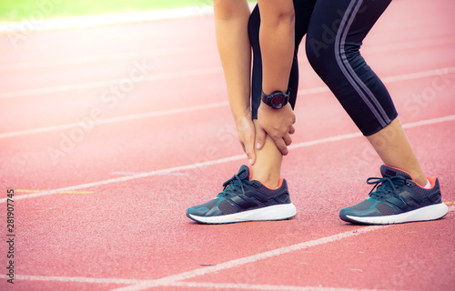 Female runner painful twisted or broken ankle injury and pain on running track,Injury from workout concept