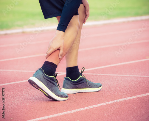 Male runner painful twisted or broken ankle injury and pain on running track,Injury from workout concept