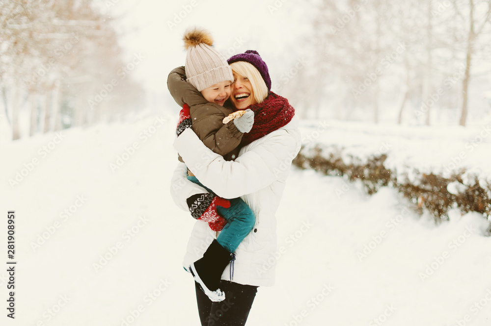 Photo of a mother hugging her son and laughting in a winter walk