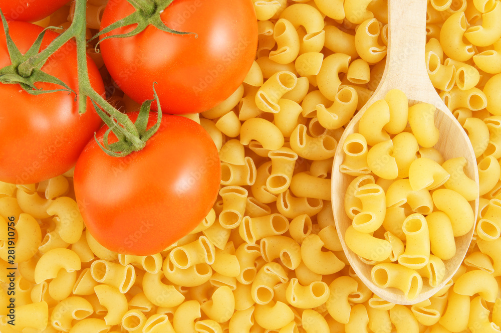 Macaroni with wooden spoon and tomatoes