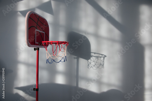 Sunlight illuminates the indoor red toy basketball circle to form a beautiful light and shadow