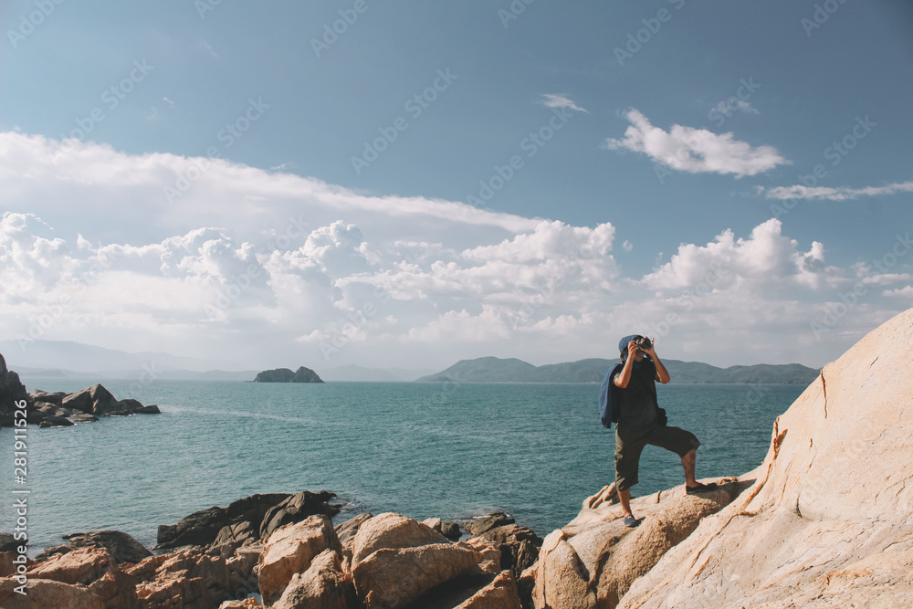 Professional photographer taking picture on the rocky beach of Phu Yen, Vietnam