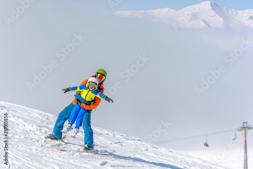 dad and son relax and have fun skiing in the mountains. Location Georgia, Gudauri Resort
