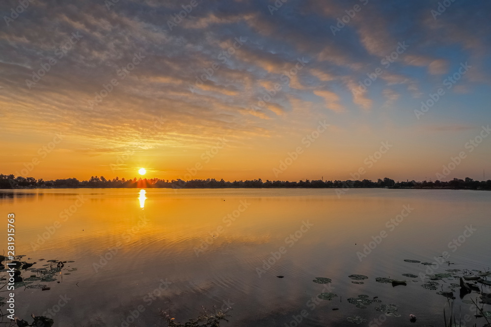 Lake view morning of yellow sun light and cloudy sky background, sunrise at Krajub reservoir, Ban Pong District, Ratchaburi, Thailand.