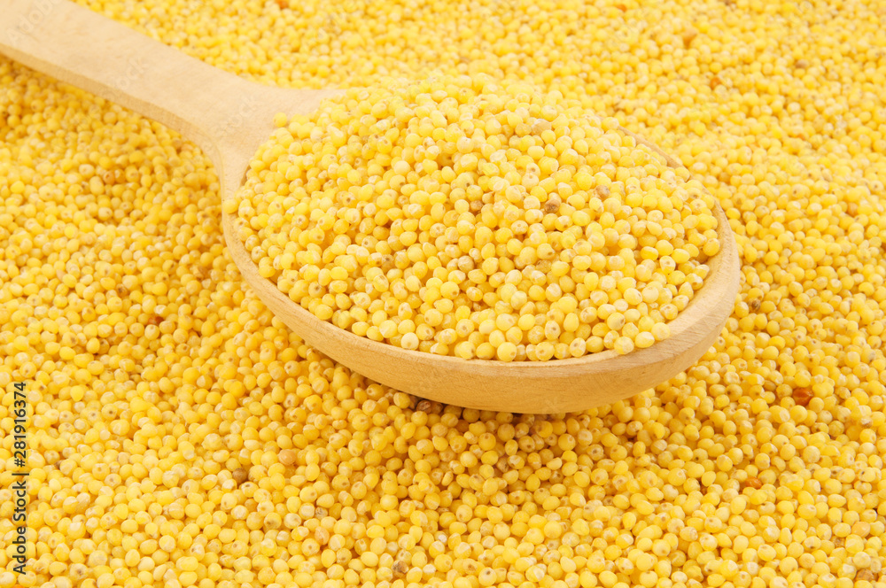 Millet with wooden spoon close up