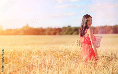 Young girl in a wheat field. Summer landscape and a girl on a nature walk in the countryside.