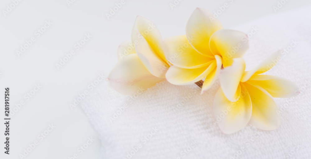 White rolled towel decoration with Frangipani flowers spa object on white background White rolled towel decoration with Frangipani flowers spa object on white background