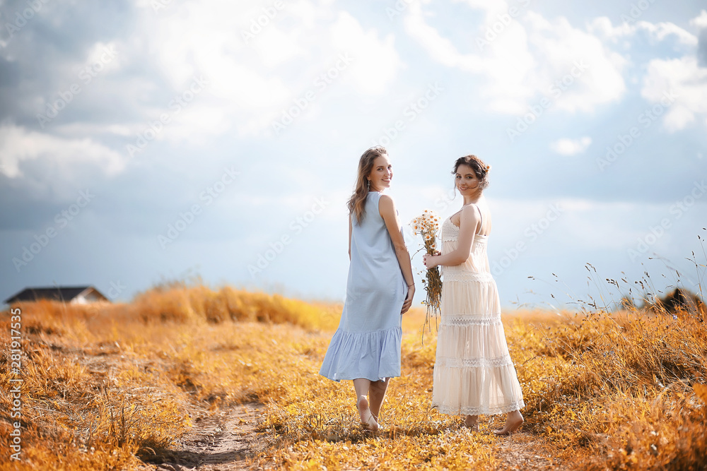 Two girls in dresses in autumn field