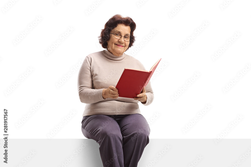 Senior woman with holding an open book and sitting on a pane Senior woman with holding an open book and sitting on a pane