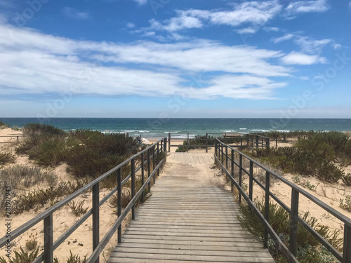 path and wooden bridge to access white sand beach algarve portugal