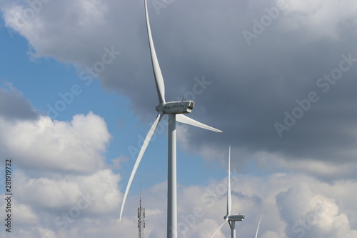 Modern windturbines with grey cumulus clouds on the sky
