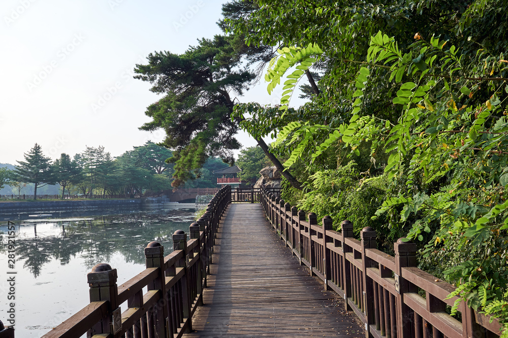 A wooden bridge over the Uirimji Reservoir leading to a gazebo overlooking the lake in Jechun, South Korea.