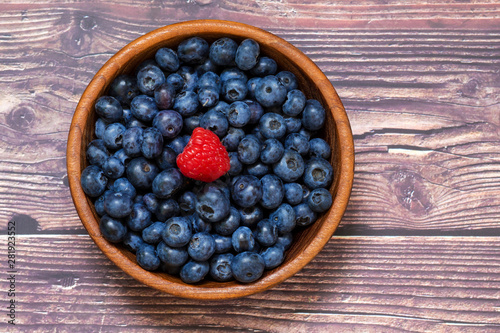 Red raspberries and blueberries in a wooden bowl. Berries, summer and vitamins