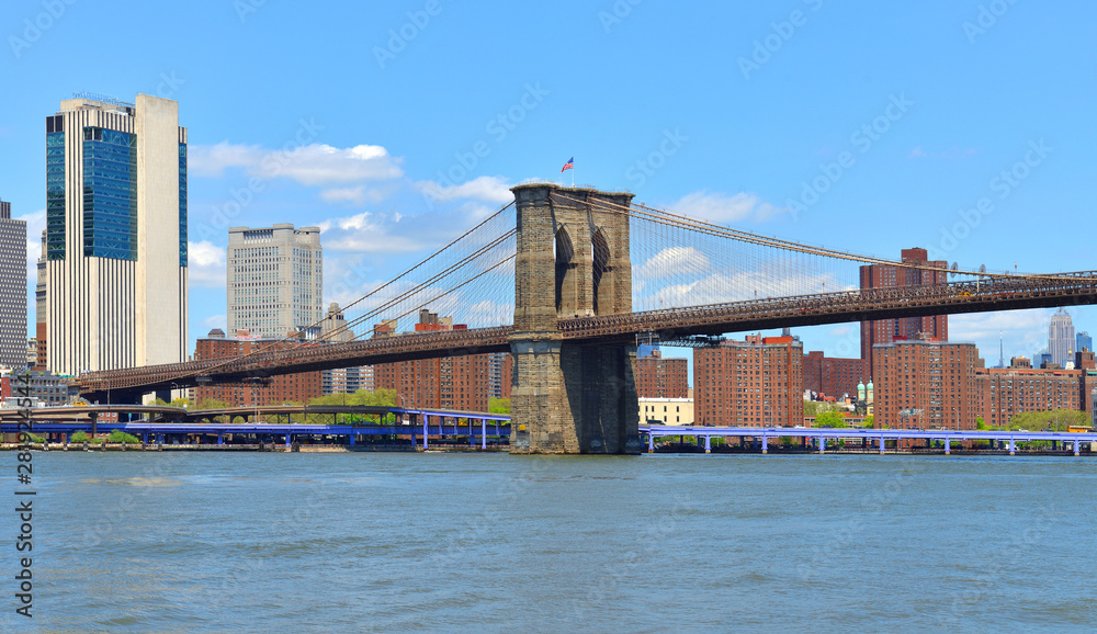 Famous Brooklyn Bridge (1883), hybrid cable-stayed, suspension bridge in New York City. USA. Bright sunny day