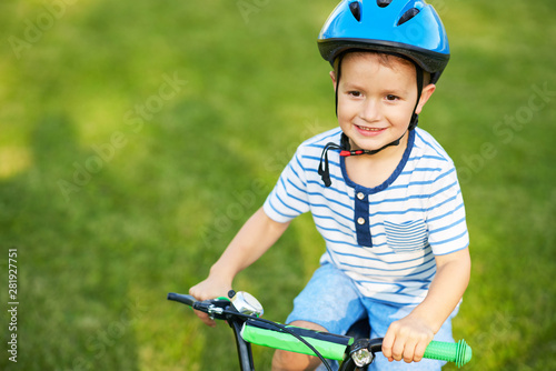 Happy 3 year old boy having fun riding a bike