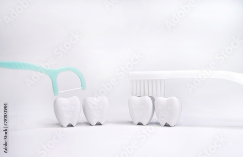 Dental Floss and Toothbrush on Tooth model in happy emotion, if brush the teeth, teeth will good hygiene 