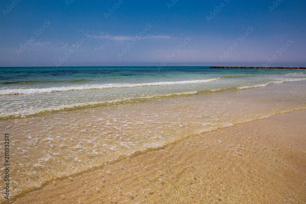 Soft blue ocean wave on sandy beach. Bottom. White sand on the beach with turquoise water in Djerba, Tunisia.