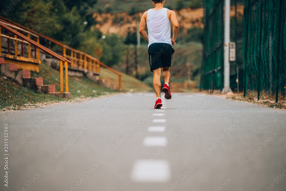 Caucasian athlete man run on running track outdoors