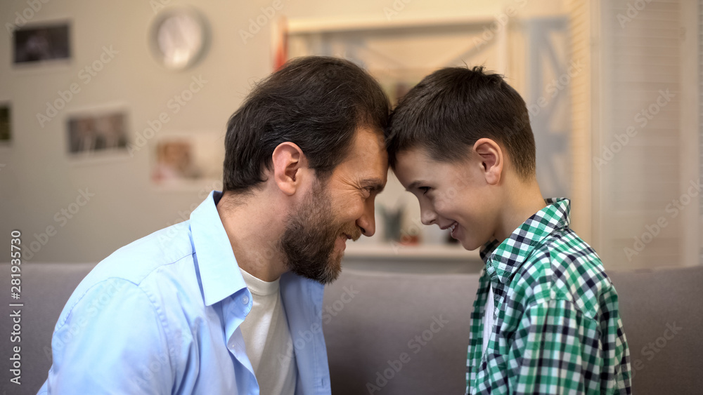 Smiling father and little son touching foreheads, trustful relations, friends Smiling father and little son touching foreheads, trustful relations, friends