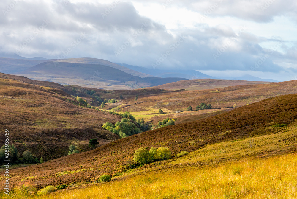 A scenic view of red and brown hills and highlands in Cairngorms national park, Scotland