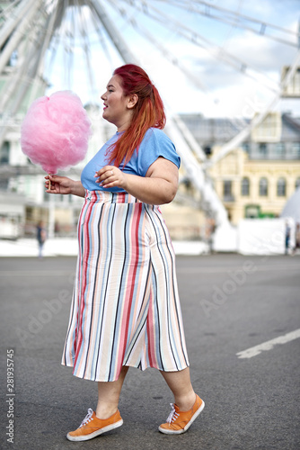 Fat and young woman with candy-floss on stick