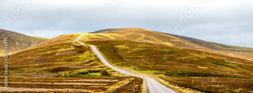 Obraz na płótnie A scenic highway through bright yellow and brown highlands during autumn season in Cairngorms national park, Scotland w salonie