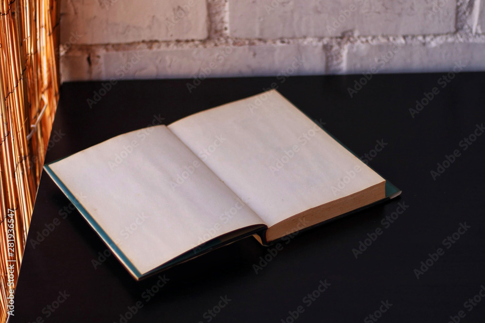 Fototapeta premium Book opened on a black table.