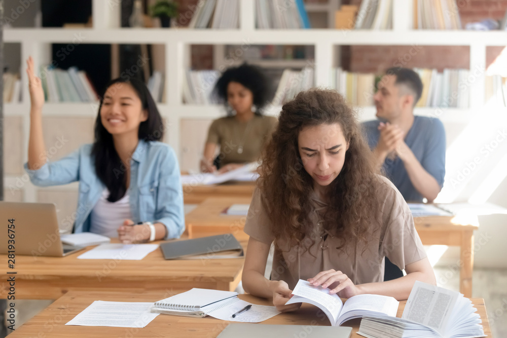 Diverse girls and guys students sitting in class during lecture Diverse girls and guys students sitting in class during lecture