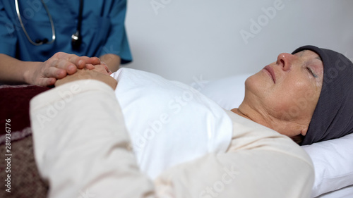 Quadro su tela Doctor supporting woman with last stage of cancer, holding her hand, hospice
