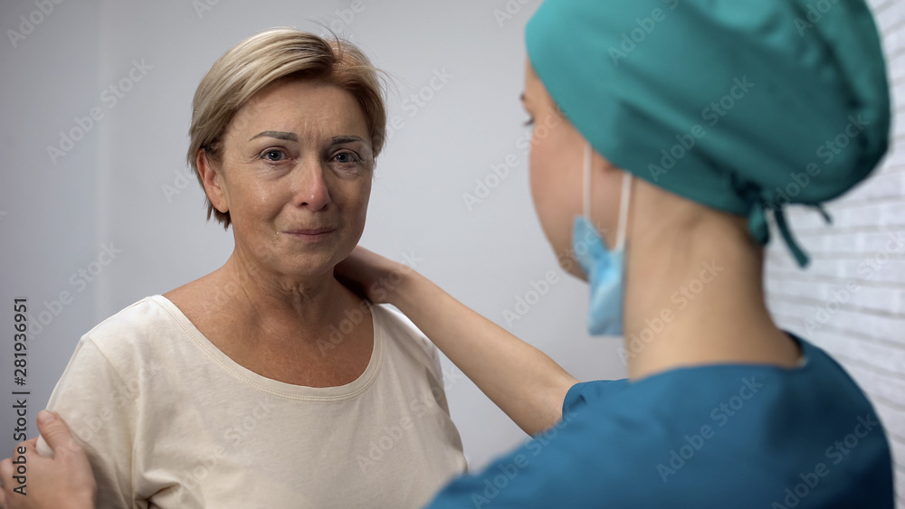 Obraz premium Caring nurse supporting adult woman with bad diagnosis, cancer in early stages