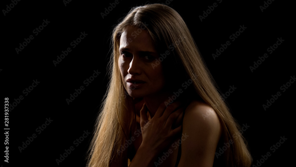 Lonely scared woman isolated on dark background, kidnapping victim, crime Lonely scared woman isolated on dark background, kidnapping victim, crime