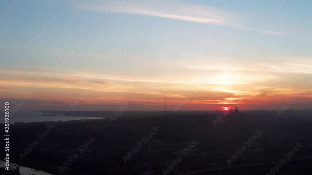 Silhouettes of buildings in the city against the sky at sunset. The city is located on the seashore. Aerial view Silhouettes of buildings in the city against the sky at sunset. The city is located on the seashore. Aerial view