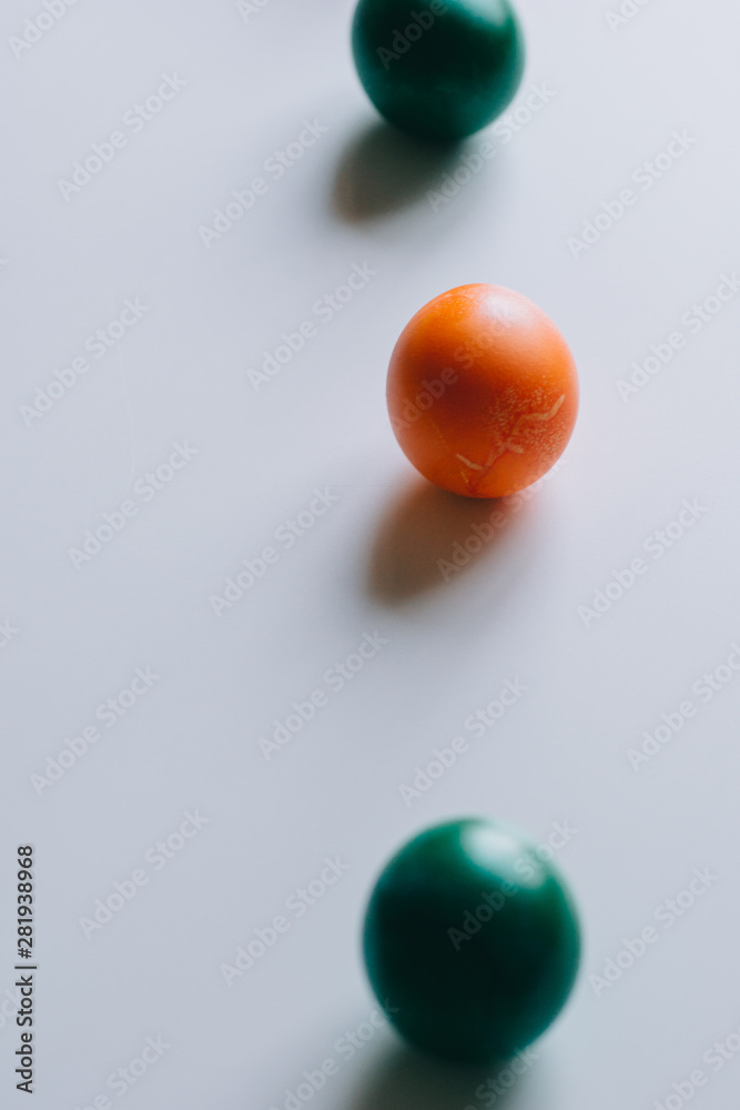 Small multi-colored Easter eggs on the kulich, festively decorated with colorful painted eggs paint, background