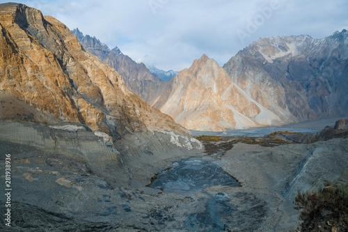 Aerial nature landscape view of mountain peaks in Karakoram range near moraine and glacial lake that melt from Passu glacier, Gojal Valley Hunza. Gilgit Baltistan, Pakistan.