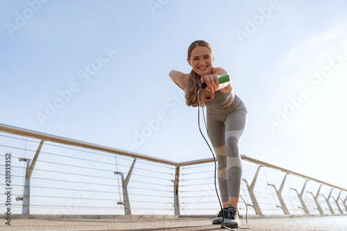 Happy lady with jump rope pointing on camera