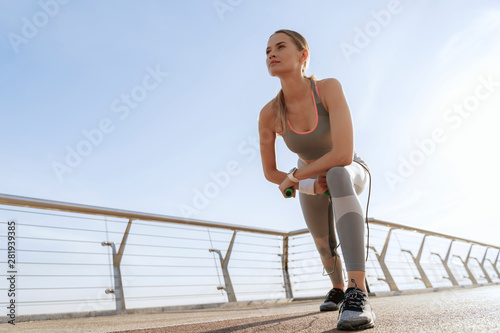 Athletic lady with jump rope on bridge