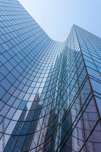 Blue glass skyscraper facade reflections against sky