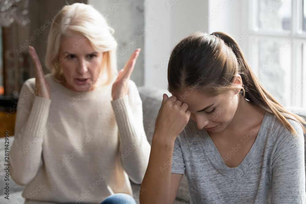 Middle aged mother scolding grown up daughter having difficult relationships Middle aged mother scolding grown up daughter having difficult relationships