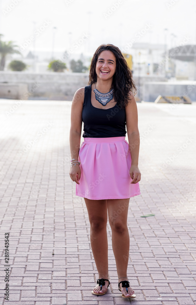 Portrait and young, beautiful and smiling woman with pink skirt and black shirt. female beauty. Portrait and young, beautiful and smiling woman with pink skirt and black shirt. female beauty.