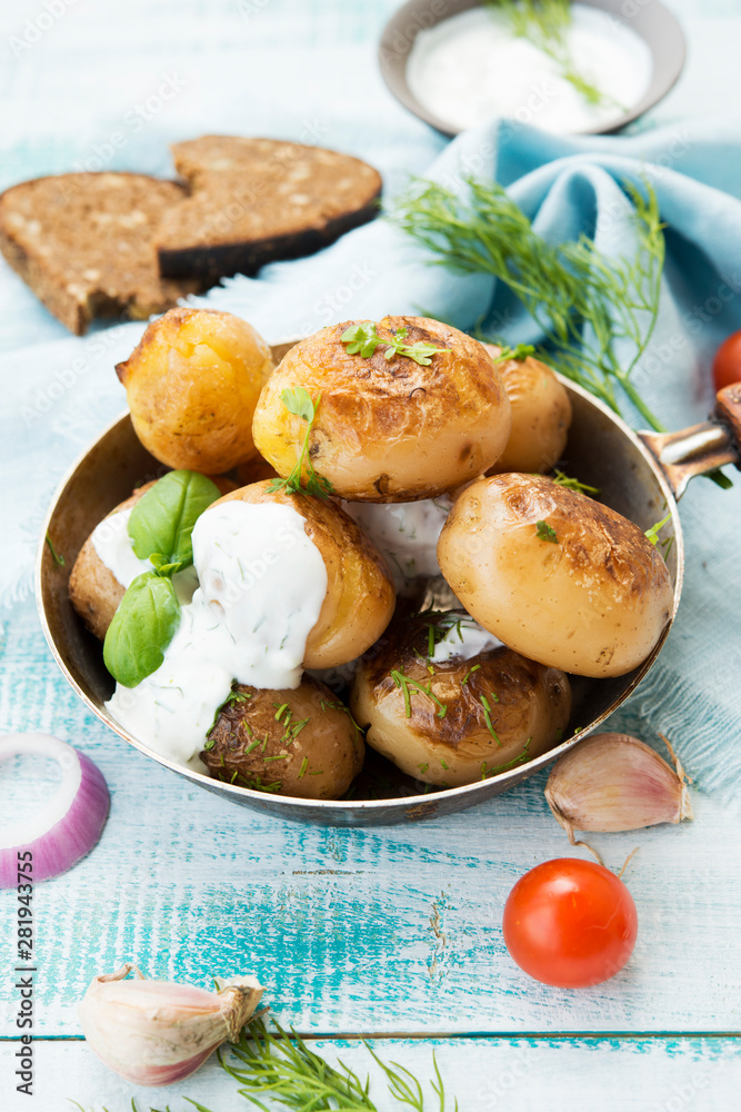 Fried potatoes in a pan with sour cream on rustic background Fried potatoes in a pan with sour cream on rustic background