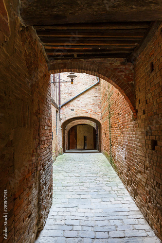 Fototapeta Naklejka Na Ścianę i Meble -  Old dark alley with brick walls